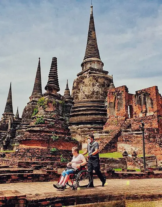 Turista en silla de ruedas paseando por Tailandia con apoyo de concierge accesible